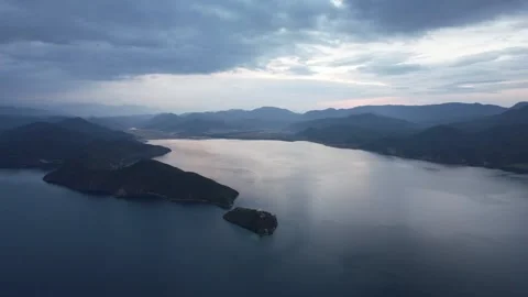 Aerial blue lake and dramatic clouds above mountain water landscape in China Stock Footage 337759443