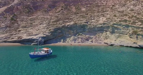 Aerial boat in crystal clear water off a beach in Greece Stock Footage