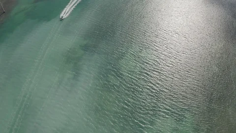 Aerial of boat driving on turquoise sea leaving tracks on water behind it, Miami Stock Footage
