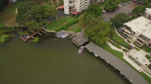 Aerial of a Boat Pulling Away from the Dock in a Lake Surrounded by Trees Stock Footage 62956831