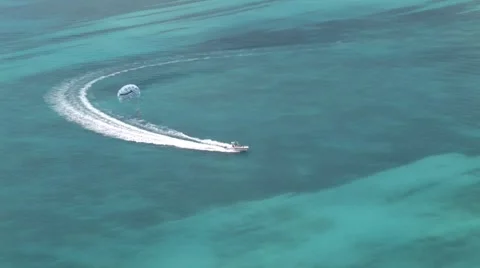 Aerial of boat pulling a parasailing or ParaSail in Beautiful Blue Water Stock Footage 5336708