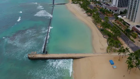 Aerial boom-down to reveal empty Waikiki Beach during Pandemic, gloomy day Stock Footage 136632139