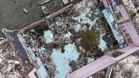 Aerial broken building with collapsed tiled courtyard and debris Video stock 329239136