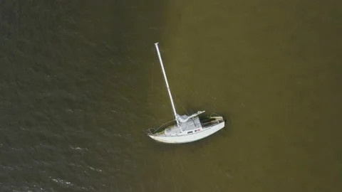 Aerial Broken down sail boat in water Stock Footage 156404577