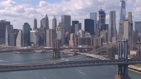 AERIAL: Brooklyn and Manhattan Bridges over East River against New York skyline Stock Footage