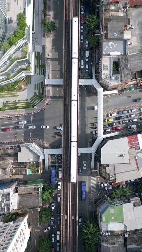 Aerial of BTS Skytrain on elevated tracks above busy street in Bangkok, Thailand 스톡 동영상 315273118
