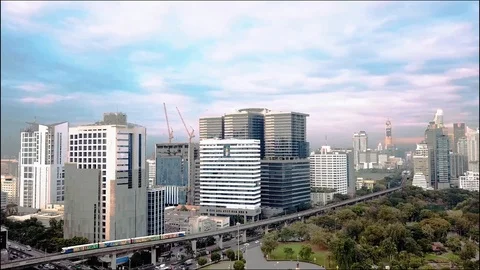 Aerial of BTS Skytrain near Lumphini Park with Bangkok's Cityscape Stock Footage
