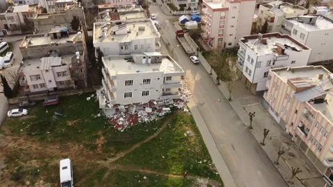 An aerial a building whose first floor was destroyed in the earthquake Stock Footage 258042993