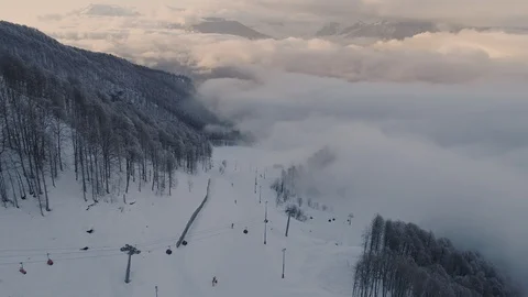 Aerial the cable car descends into the clouds under mountain Stock Footage 103475188