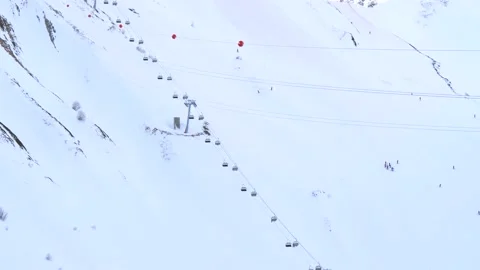 Aerial cableways with elevators and cabins are lowered and lifted up skiers Stock Footage 148856892