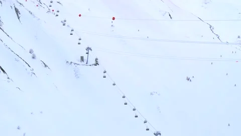 Aerial cableways with elevators and cabins are lowered and lifted up skiers Stock Footage 148856903