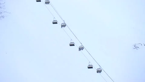 Aerial cableways with elevators and cabins are lowered and lifted up skiers Stock Footage 148857228