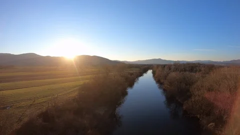 AERIAL Calm river running through the fields at sunset Stock Footage 101075963