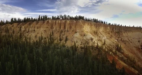 Aerial camera approaching a cliff of a pine forest canyon on a sunny day Video stock 118642877