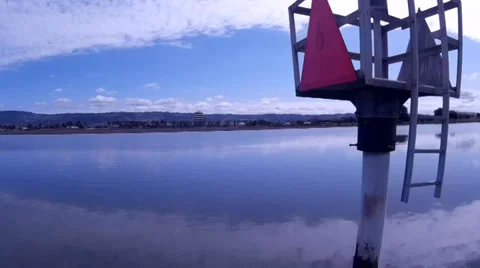 Aerial Camera Backtracks Over Calm Bay Waters Passing Buoy Video stock 37579812