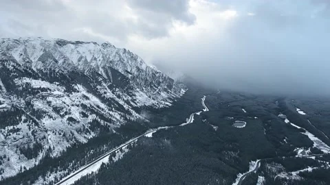 Aerial camera capturing heavy winter clouds descending in valley in Alberta Video stock 143234204