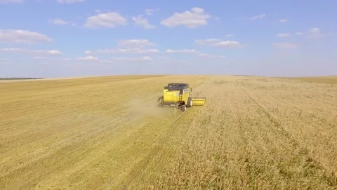 AERIAL: The camera flies low over the harvesters to the horizon. Stock Footage 81839918