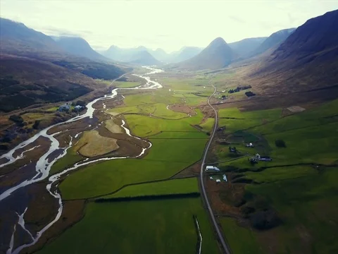  Aerial camera follows river through beautiful green valley. Stock Footage 80826224