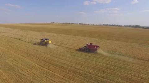AERIAL: The camera make a semicircle above the working harvesters. Video stock 81839825