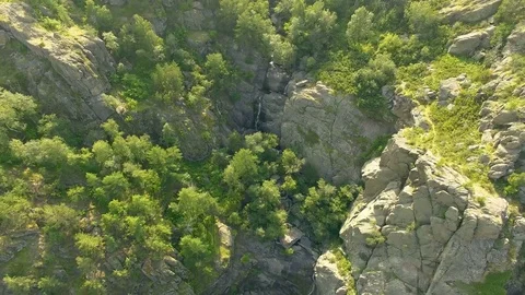AERIAL: Camera move away from waterfall to the far plan of rocky mountains Stock Footage 78032263