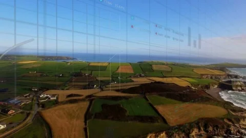 Aerial camera moving forward over coastal farms, initiating HUD bar charts Stock Footage 333131962