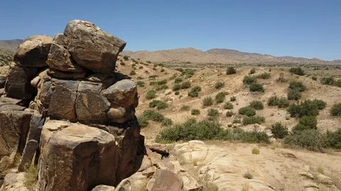 Aerial camera orbits striking wild-west rock formation, Yucca Valley Stock Footage 114135710