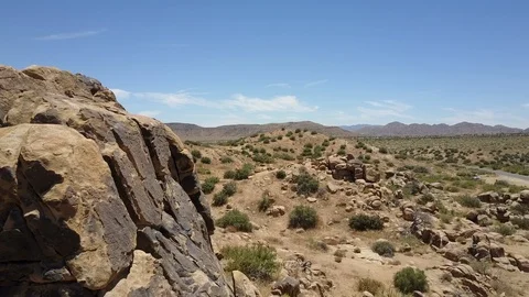 Aerial camera orbits striking wild west style rock formation, Yucca Valley Stock Footage 114135784