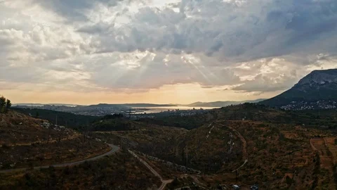Aerial camera rising over a small hillside with a epic sunset and cloud Stock Footage 122807735