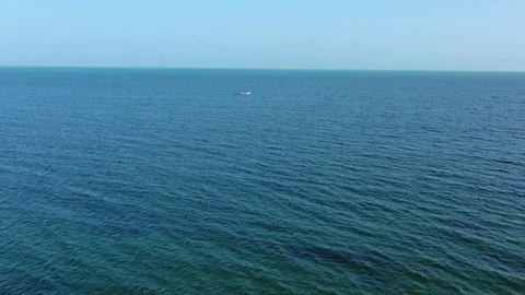 Aerial camera speeds toward a small fishing boat in the Caribbean. Video stock 104682389