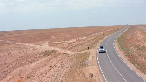 Aerial camera tracking car approaching forward front view along curved asphalt Stock Footage 334027020