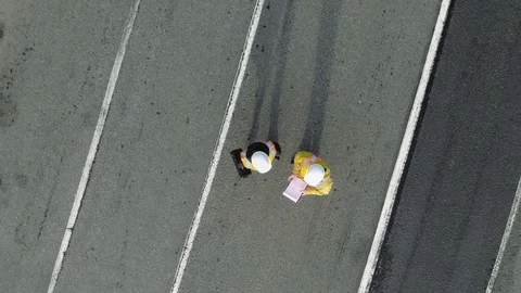 AERIAL. Camera zooming out. Image of two workers standing and talking at Stock Footage 101228786