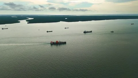 Aerial: cargos on the Strait of Malacca at sunset next to Royal City of Klang Stock Footage 309965101