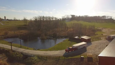 Aerial of cattle farmer pulling trailer out of his farm. Video stock 102779205