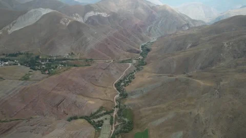 Aerial Chalus Road canyon shows a thin green valley floor cutting through wide Stock Footage 343907341