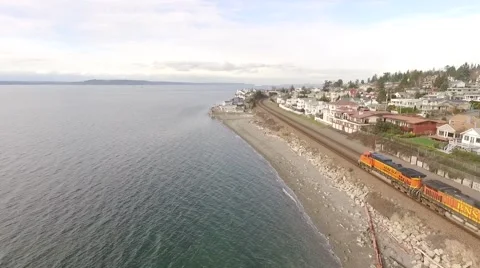 Aerial - Chasing Freight Train on shoreline of Puget Sound Seattle Washington 2 Stock Footage 60114191