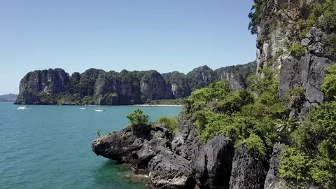 Aerial cinematic low flight view: cliffs, tropical sea, boats, beach, islands Stock Footage 73041026