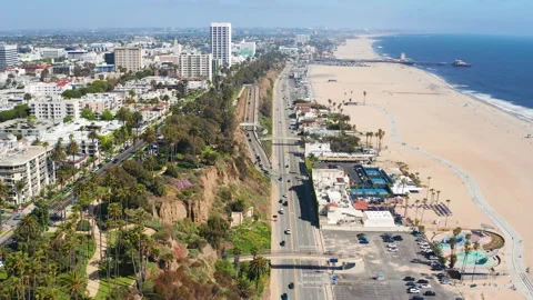 Aerial cinematic pullback shot of Santa Monica Los Angeles beach coast streets Stock Footage 308132722