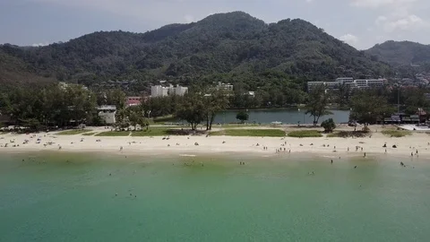 Aerial cinematic view (camera back): beach with many people and tropical sea Stock Footage 72014523