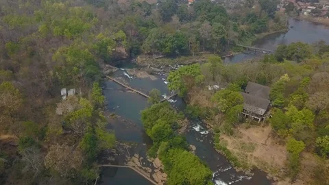 Aerial cinematic view: Flight over village with beautiful waterfall and river. 스톡 동영상 101948989