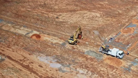 Aerial circle around a track loader and worker moving soil Stock Footage 266475530
