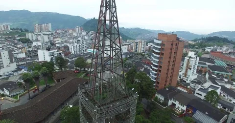 Aerial circle of El Cable tower rises up to reveal rest of city of Manizales Видео 72244936