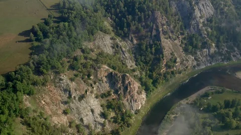 Aerial circle: Tracking flight from left to right through clouds to cliff view. Stock Footage 114720468