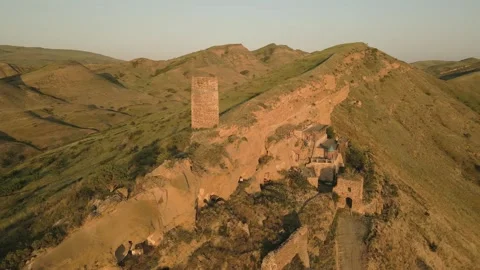 Aerial circular view of an ancient stone watchtower standing alone on a rem.. 動画素材 312444315