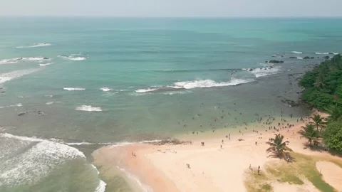 Aerial circular view crowded beach in Tangalle, Sri Lanka, where tourists e.. Stock Footage 309738472