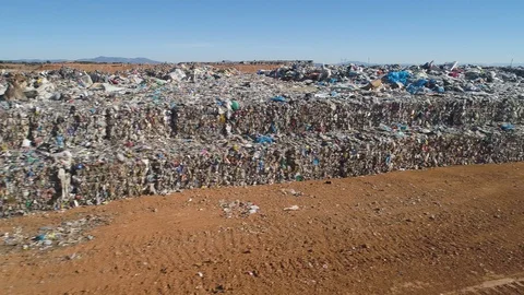 Aerial: City dump. Compressed in cubes garbage stacked and covered in soil Stock Footage 102033048