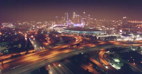 Aerial city traffic freeway night flying forward downtown Los Angeles skyline Stock Footage