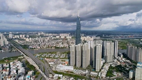 Aerial: Cityscape Hyper-lapse over Saigon. Clouds above bustling traffic below. Stock Footage 111716082