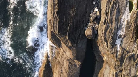 Aerial cliff view where the waves break against stones in Asturias Stock Footage