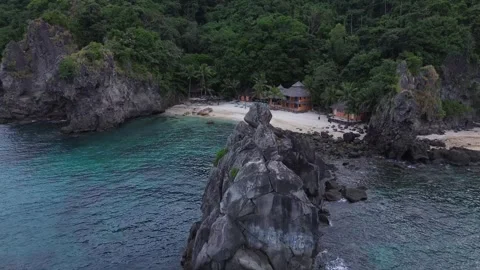 Aerial cliffs with hidden secret beach and bungalow Apo Island Philippines Video stock 332619048