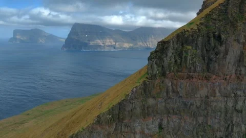 Aerial cliffside approach above basalt sea cliffs and fjords in Faroe Islands Stock Footage 336293840
